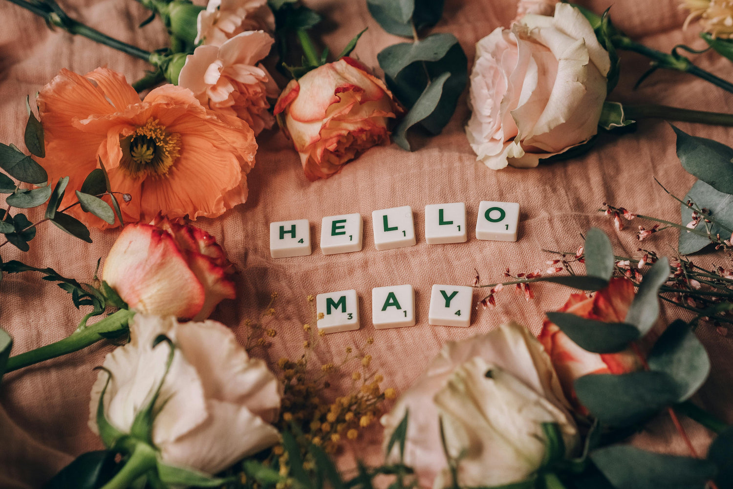 Hello May written in Scrabble letters with flowers surrounding area a 